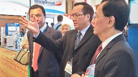Sauu Kakok (center), VP of Hess Asia Pacific, gives a tour of the Hess booth to PETRONAS&#39; visiting officials